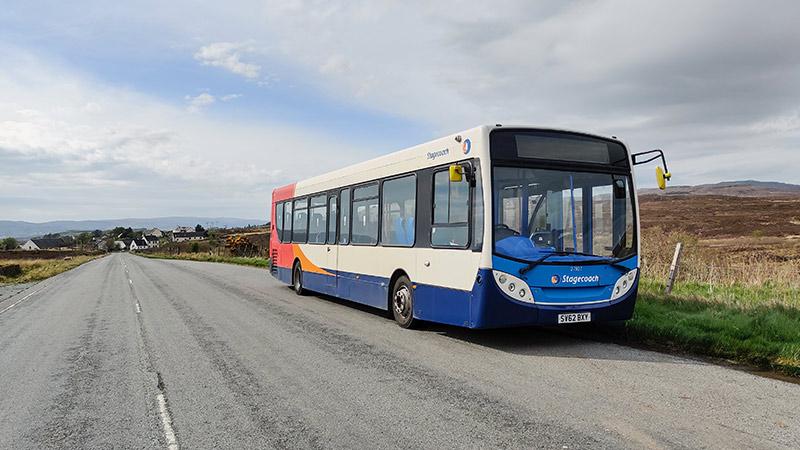 Stagecoach bus parking near a village on the side of the road in summer time