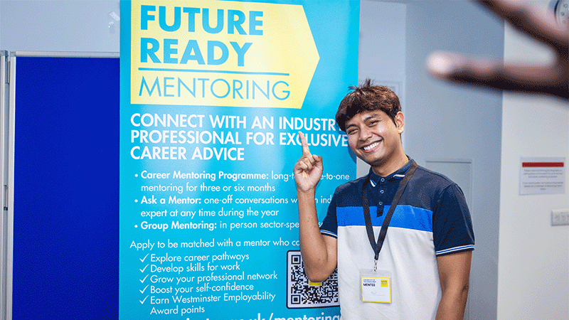 Student posing near Future Ready Mentoring sign