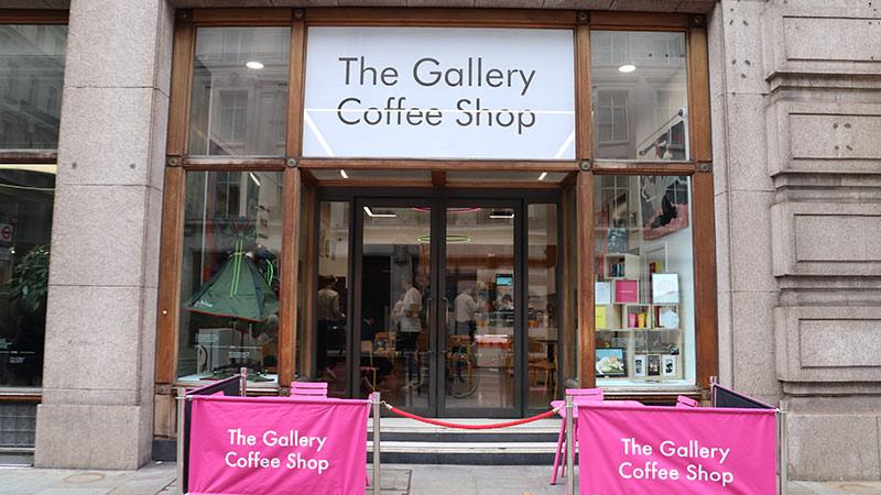 The Gallery Coffee Shop entrance with pink signs and art works on the display