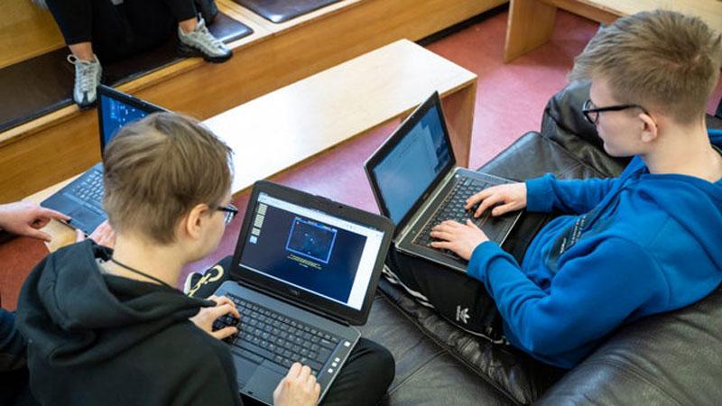 Two vulnerable people sitting down and using laptops 