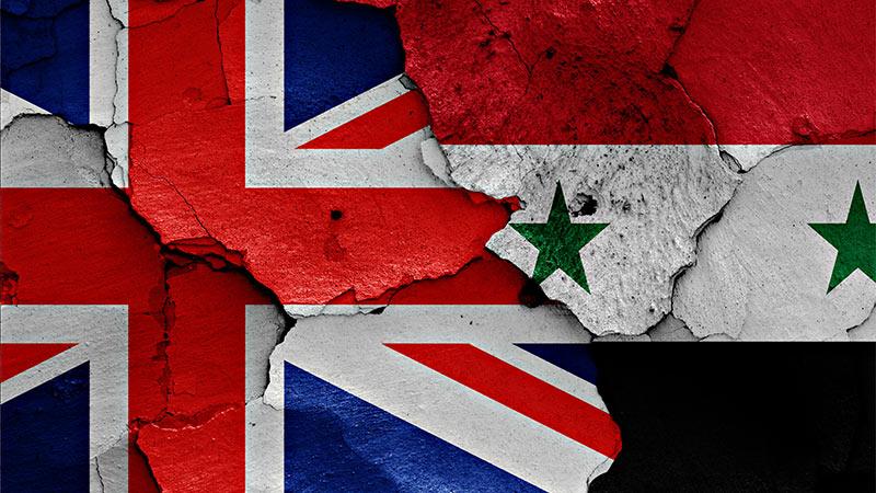 UK and Syrian flag painted on a cracked wall