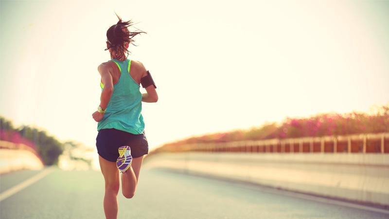 Woman running in the middle of an empty road