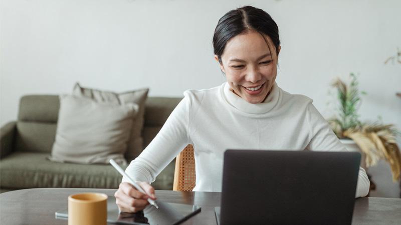 Female student sat at desktop in front of laptop