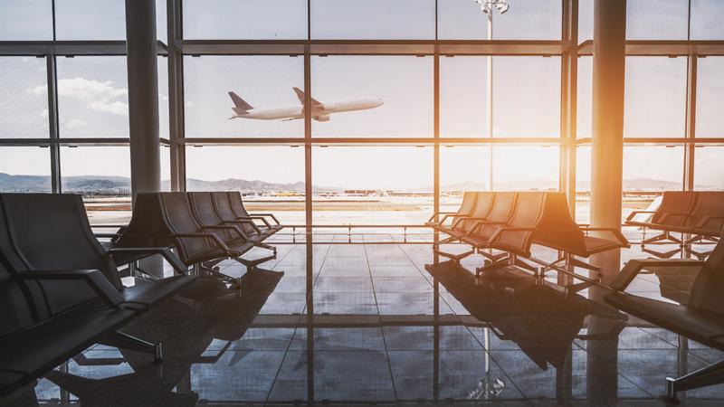 Airport waiting area with plane outside window in background