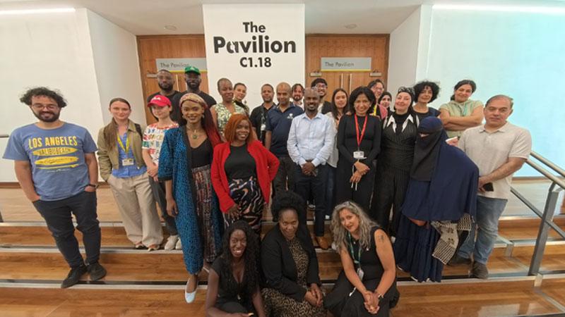Group photos of attendees at the Beyond Borders event standing in front of a sign reading The Pavilion