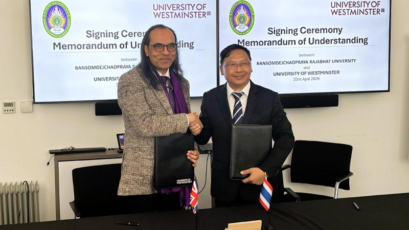 Photo of Professor Dibyesh Anand and Dr Kanakorn Sawangcharoen shaking hands as they formalise the Memorandum of Understanding between the two universities. In front of them are the UK and Thai flags.