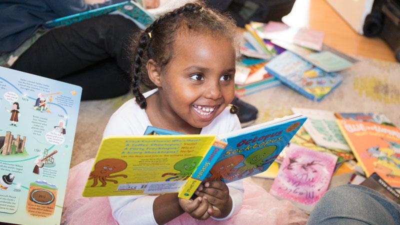 Child reading book as part of Doorstep Library initiative