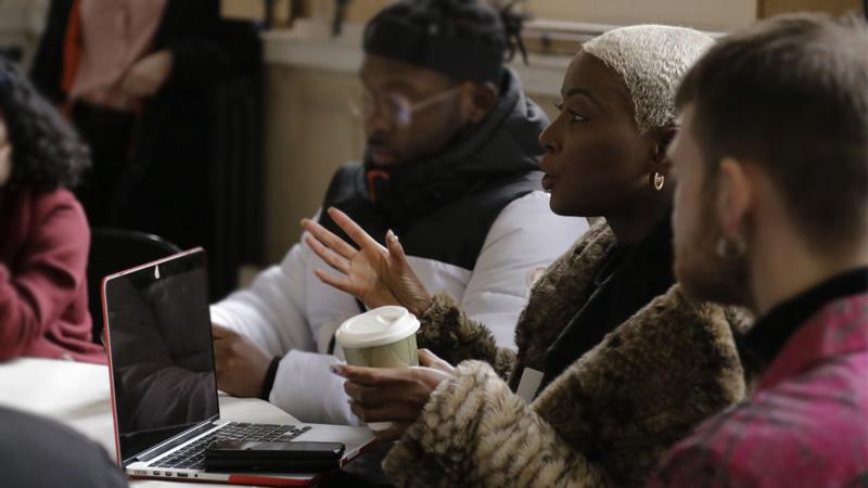 Student Esther Bokuma talking whilst sat amongst other colleagues