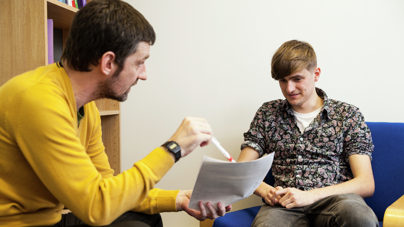 University of Westminster, Harrow Campus. A male, sitting on the left, talking to a male student sitting on the right