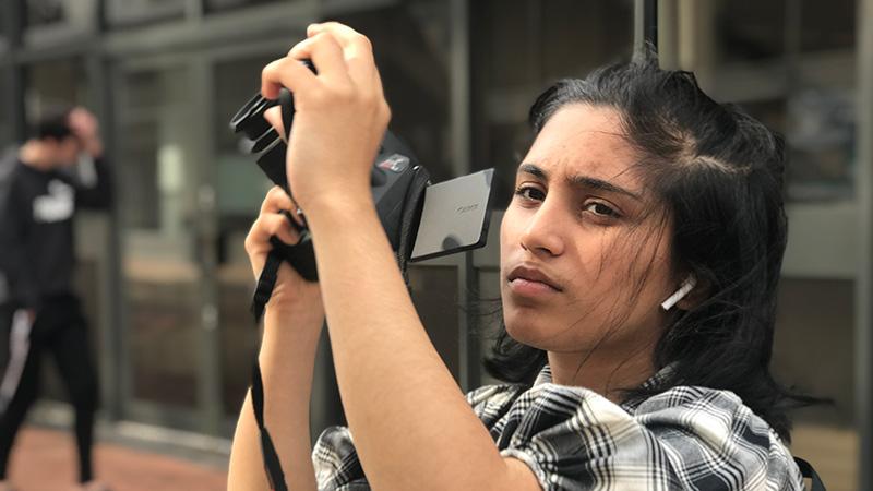 Hareem Qureshi holding a camera on the Only Love Matters set.