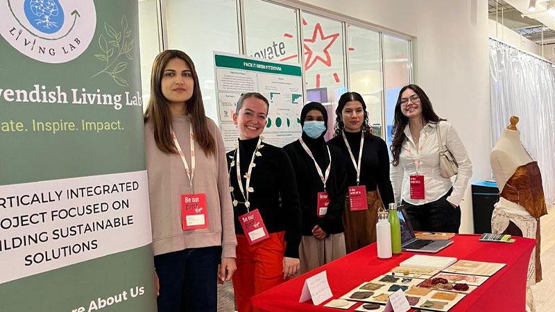 Team photo of Greener Futures Leaders at a presentation stand next to a banner with information about Cavendish Living Lab