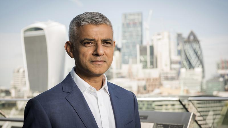 Headshot of Mayor of London Sadiq Khan with London skyline in background