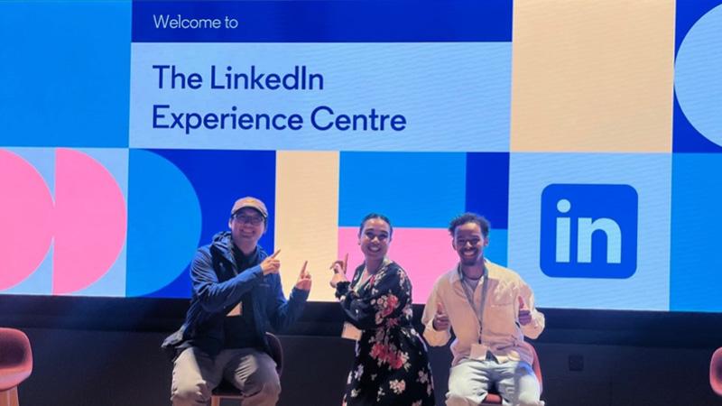 Students sat in front of a wall that reads "Welcome to the LinkedIn Experience Centre"
