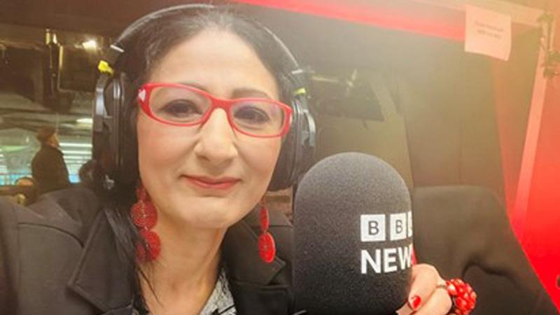 Professor Nitasha Kaul sat in the BBC radio studios with a microphone that says "BBC NEWS"