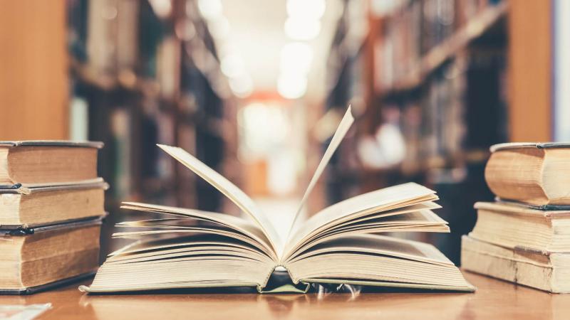 Picture of an open book in a library.