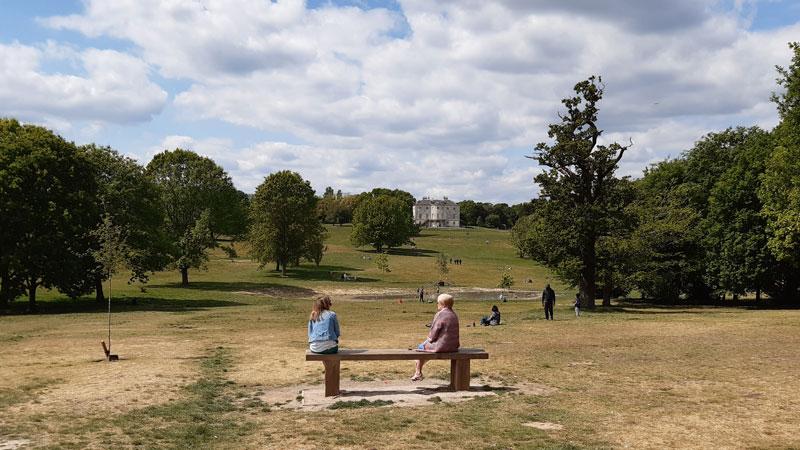 Two people socially distanced on a bench at Beckenham Place Park
