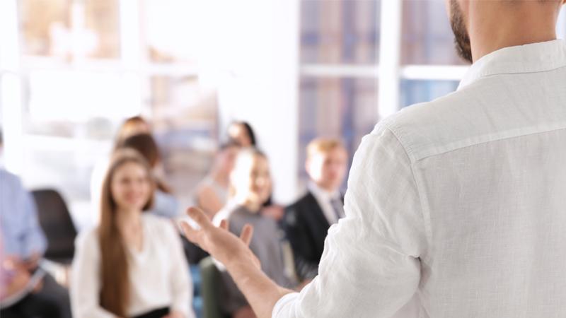 Person delivering seminar to group of guests