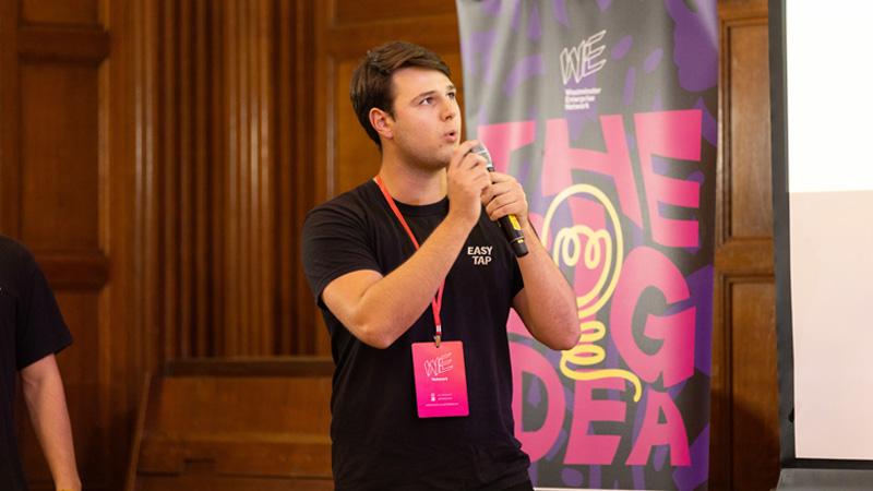Riccardo Facciolongo speaking into a microphone in front of a banner which reads: THE BIG IDEA
