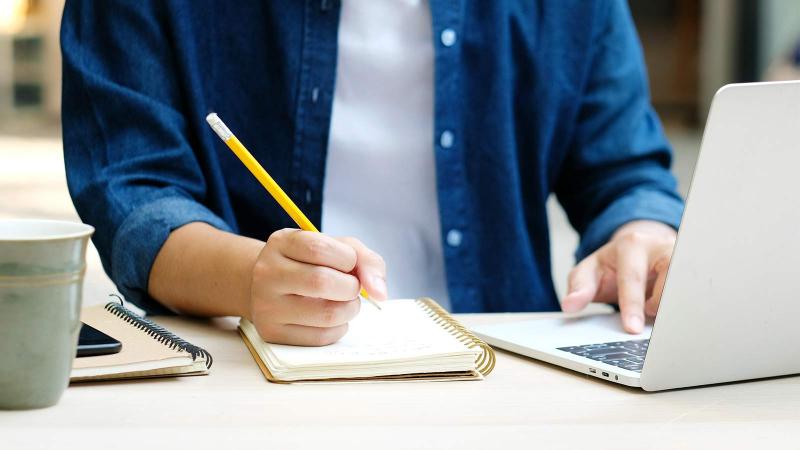 Student taking notes during an online event feature