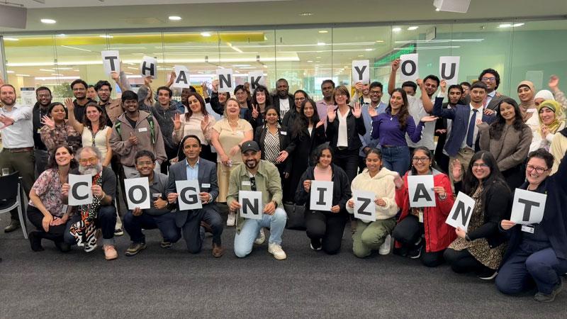 Participants holding up sheets of paper that spell out "THANK YOU COGNIZANT"