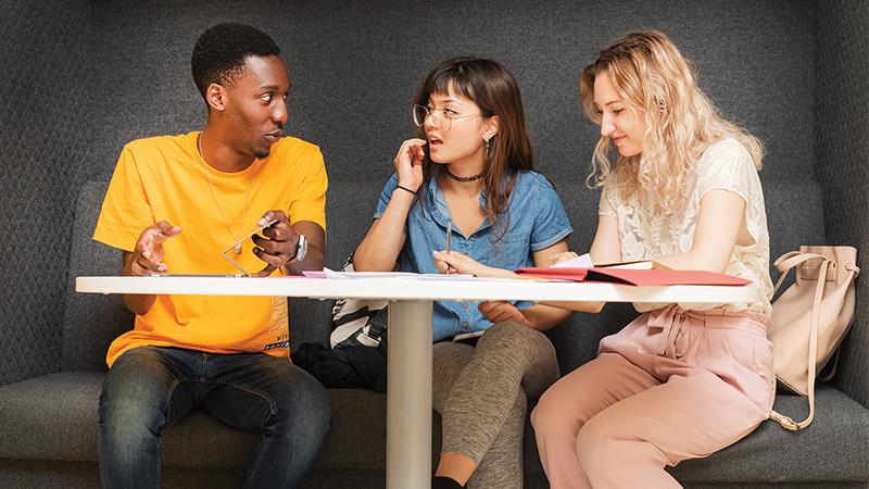 Three students seated and talking