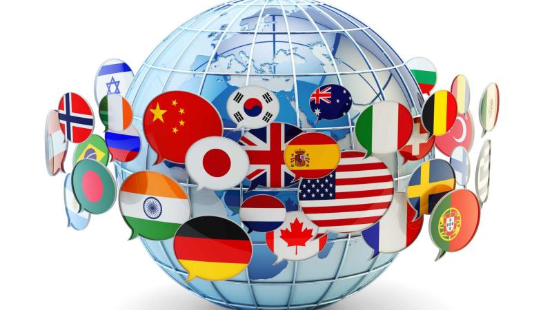 Stock image of a globe with flags of different countries wrapped around it.