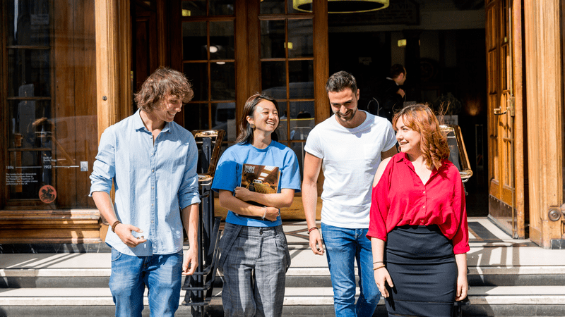 four people walking down steps and smiling