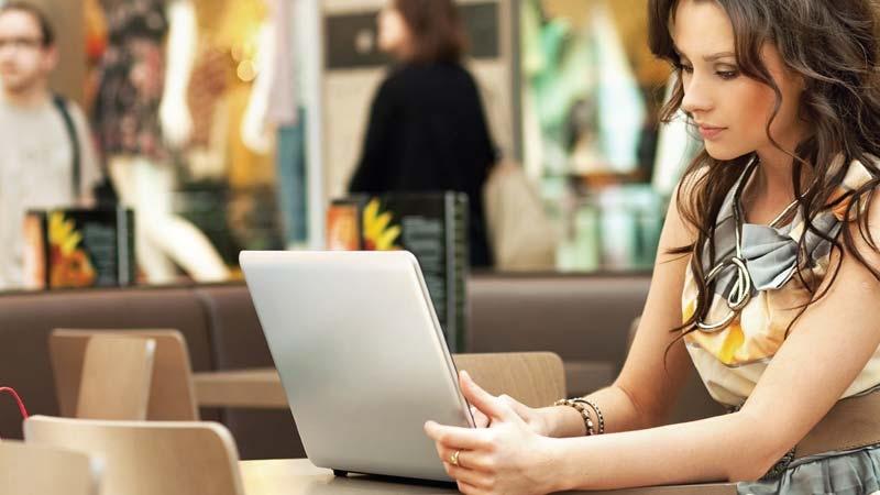 Woman using laptop in coffee shop