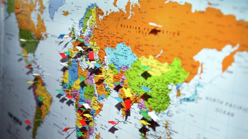 World map with flag pins in different countries