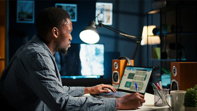 A young man working on a laptop.