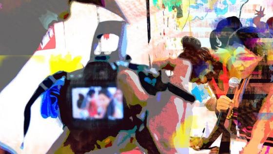 A glitched image of someone filming a speaker