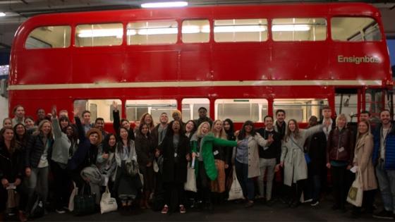 A group of students standing in front of a bus
