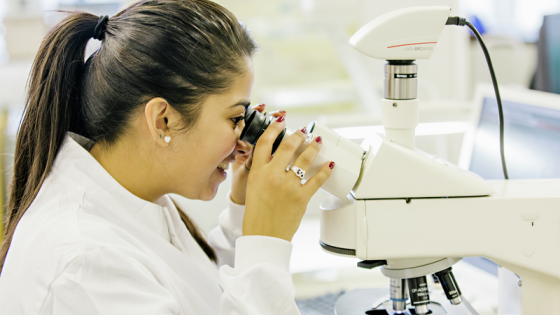 A woman looking through a microscope