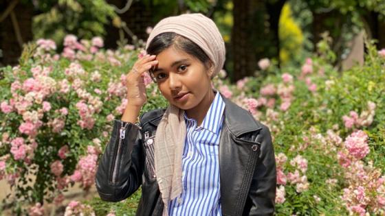 Sudent Naseha Malik stood in front of flowers