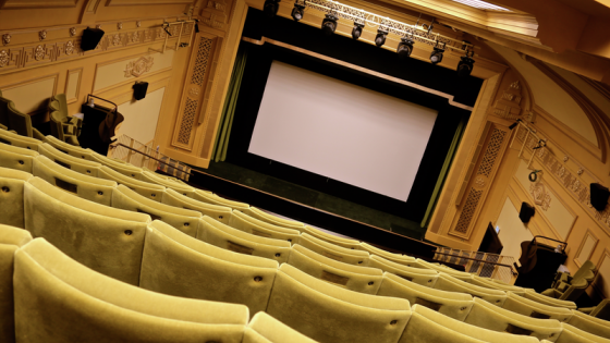 A large cinema screen with cinema chairs