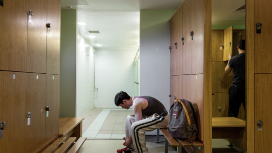 A room with lockers and a shower room in the background