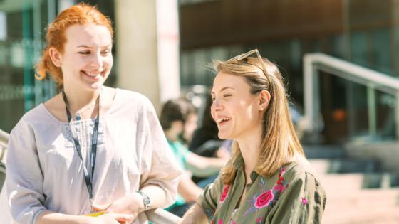 Two people smiling and talking