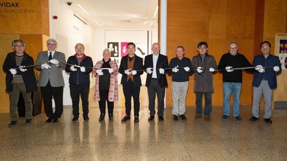 VIDAK members cutting a ribbon in front of the gallery