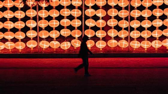 Silhouetted figure in front of a backdrop of Chinese lanterns