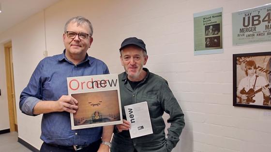 Alan Porter and friend, attendees at the original New Order gig, holding bootleg of the performance
