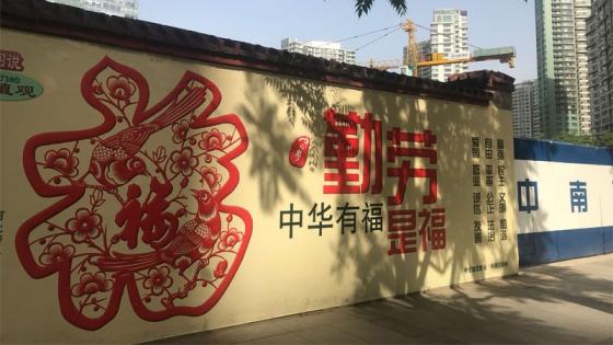 A wall with Chinese drawings and signs painted on it