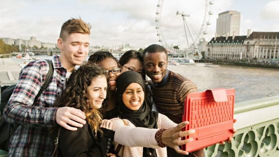 Students taking a selfie with an ipad on a bridge in Central London