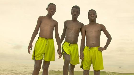 Three black boys standing together wearing shorts