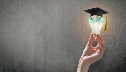 Student success with world lightbulb on teacher chalkboard